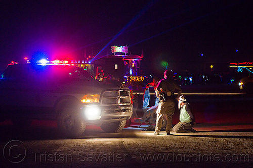 burning man - blm rangers arrest a man riding a scooter, arresting, blm rangers, burning man at night, law enforcement, leo, lorry, motorcycle, officers, police action, police arrest, police lights, suv, truck, under arrest