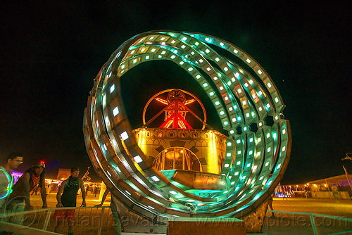 burning man - giant animated steel rings sculpture with led lights, animated, art installation, burning man at night, disc-go-sphere, glowing, led light, rings, sculpture, the man