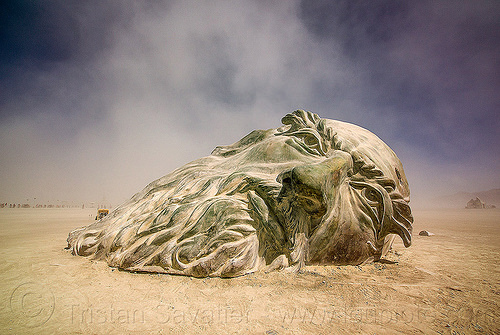 burning man - giant da vinci's head half buried in the playa, art installation, da vinci head, giant head, sculpture