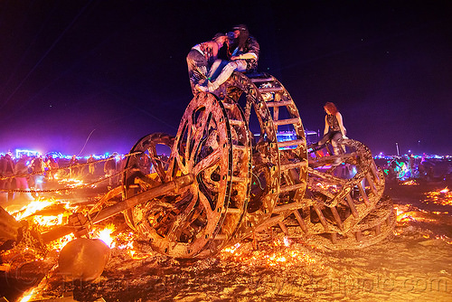 burning man - giant gears wreckage, burning man at night, embers, fire