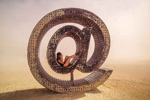 burning man - @ - giant letter sculpture, @earth #home, art installation, big words, metal sculpture, steel, woman