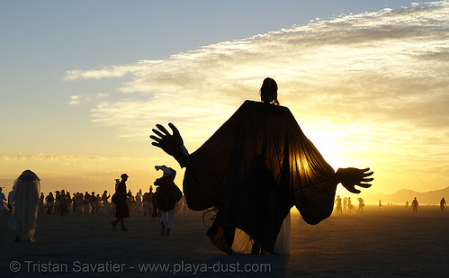 burning man - giant puppet at the silent white procession, back light, coyote rising, dawn, giant puppet, white morning
