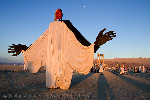 burning man - giant puppet at the silent white procession, coyote rising, dawn, giant puppet, white morning