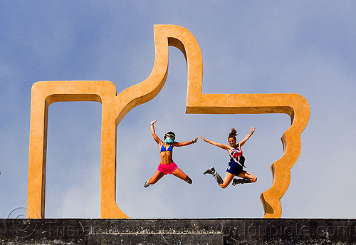 burning man - girls jumping in the facebook golden like hand, art installation, dadara, facebook hand, facebook like, golden like, icon, jumpshop, like4real, sculpture, thumb up, women