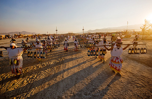 burning man - lamplighters in sunset procession, lamplighters, petrol lanterns, poles