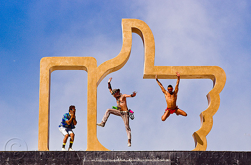 burning man - men jumping in the giant golden hand, art installation, dadara, facebook hand, facebook like, golden like, icon, jumpshop, like4real, men, sculpture, thumb up