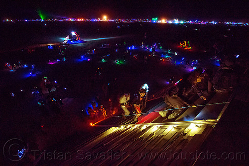 burning man - people climbing the giant pyramid at night, art installation, burning man at night, catacomb of veils, climbing, glowing, pyramid, sculpture