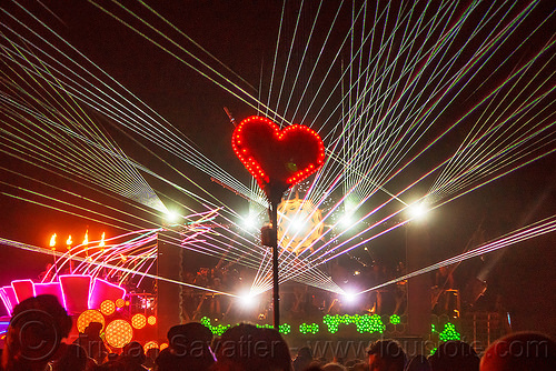 burning man - red heard on stick glowing in the night - white lasers, burning man art cars, burning man at night, dancing, mutant vehicles, unidentified art car, white lasers