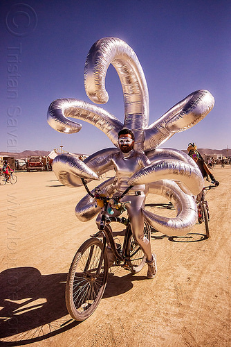 burning man - shiny inflatable costume with long arms, attire, beard, bicycle, bike, burning man outfit, inflatable art, inflatable costume, mask, masked, riding, shiny, tentacles