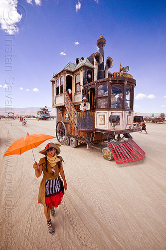 burning man - the neverwas haul art car, art car, burning man art cars, mutant vehicles, neverwas, orange umbrella, steampunk, victorian, walking, woman