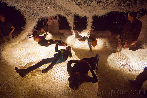 burning man - zipties art installation, burning man at night, glowing, laying down, sitting