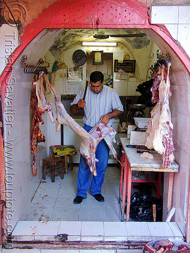 butcher in meat shop, butcher knife, carcass, carcasses, chevon, cleaver, cutting, goat meat, halal meat, hanging, hooks, kurdistan, man, mardin, meat market, meat shop, mutton, raw meat, worker