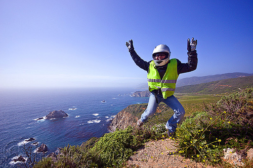 california coast near big sur, big sur, california coast, carmel, cliff, gloves, islets, jump shot, leather jacket, monterrey, motorbike helmet, motorcycle helmet, pacific ocean, refective jacket, rocks, safety jacket, sea, seashore, sunglasses, trail, woman