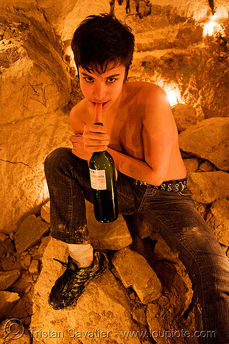 cataphile in candle-lit cave - catacombs of paris (off-limit area), candles, cataphile, cave, clandestines, illegal, new year's eve, underground quarry, wine bottle, woman