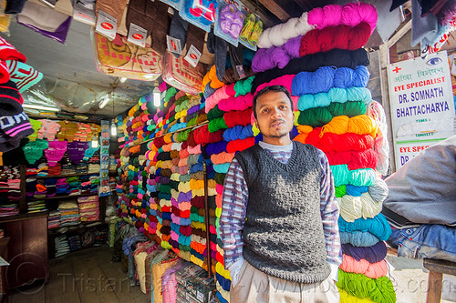 colorful cotton skeins in shop - darjeeling (india), colorful, darjeeling, india, man, merchant, rainbow colors, shop, skeins, standing, store, vendor, wool