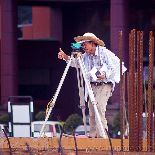 construction surveying - theodolite - tripod, borneo, building construction, construction site, construction surveying, construction surveyor, construction workers, geometer, malaysia, man, miri, rebars, straw hat, sun hat, survey, theodolite, thumb up, tripod, working