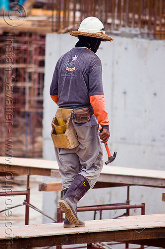 construction worker - tool pouch - hammer, borneo, building construction, construction site, construction workers, hammer, lumber, malaysia, man, miri, rubber boots, safety helmet, scaffolding, shoring, straw hat, sun hat, timber, tool belt, tool pouch, walking