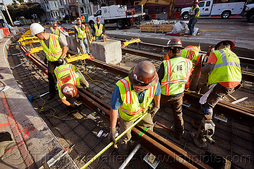 construction workers replacing tracks of the san francisco municipal railway, construction workers, duboce, guard rails, high-visibility jacket, high-visibility vest, light rail, measuring tape, men, muni, ntk, railroad construction, railroad tracks, railway tracks, reflective jacket, reflective vest, safety helmet, safety vest, san francisco municipal railway, track maintenance, track work, working