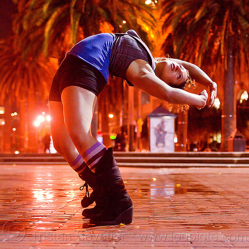 contortionist leaning backward - street artist (san francisco), back stretching, brick floor, brick tiles, contortionist, night, stretch, woman