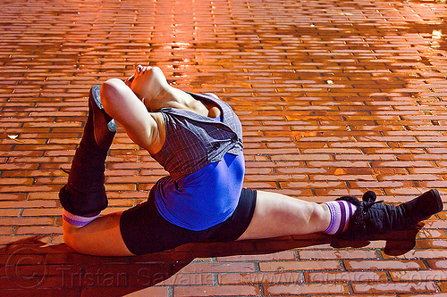 contortionist leaning backward - street artist (san francisco), back stretching, brick floor, brick tiles, contortionist, night, stretch, woman