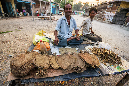 dried tobacco leaves at street market (india), boy, cross-legged, dried, gairkata, india, man, sitting, stall, street market, street seller, tobacco leaves, vendor, west bengal