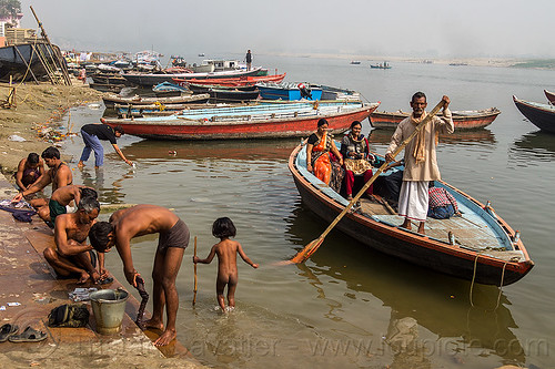 family bathing and doing laundry in ganges river at the ghats of varanasi (india), bathing, boatman, child, ganga, ganges river, ghats, hindu, hinduism, kid, laundry, little girl, men, metal bucket, moored, mooring, nadi bath, paddle, river bank, river boats, rowing boat, sailing, small boat, steel bucket, varanasi, washing, woman