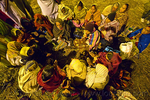 family of hindu devotees praying in a circle (india), ceremony, family, hindu pilgrimage, hinduism, kumbh mela, men, offerings, paush purnima, pilgrims, praying circle, ritual, sitting, straw, women