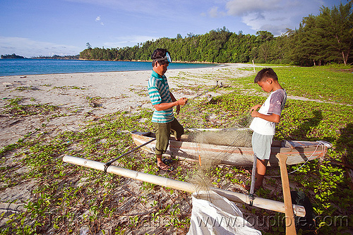 fishermen checking their fishing net, bangka, borneo, boy, climbing plants, creeper plants, double outrigger canoe, fishermen, fishing canoe, fishing net, kelambu beach, malaysia, man, ocean, river boat, rowing boat, sand, sea, seashore, small boat