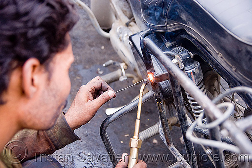 getting my cracked rack welded (again) - leh (india), fixing, ladakh, luggage rack, man, motorcycle touring, repairing, road, royal enfield bullet, welder, welding, worker, working