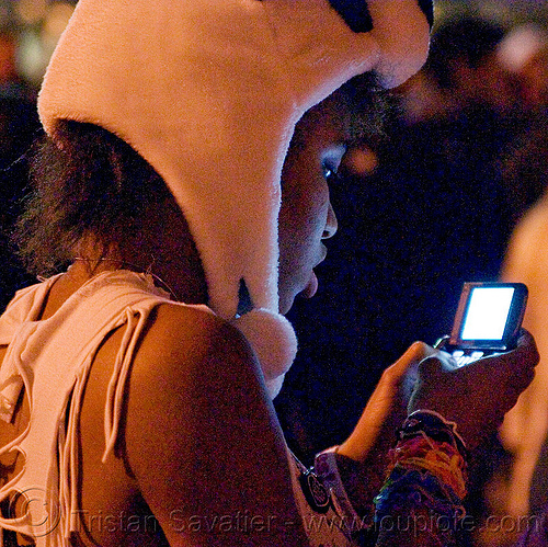 girl texting at pillow fight street party (san francisco), black woman, cellphone, night, panda hat, teen, teenager, texting, world pillow fight day