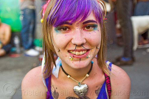 girl with face piercings - kiki, cheek piercings, gay pride festival, heart necklace, kiki, lip piercing, mustache septum jewelry, nose piercing, purple hair, septum piercing, snake bite piercings, snake bites piercing, woman