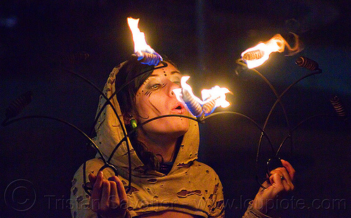 grace blowing off her fire fans, blowing off, fire dancer, fire dancing, fire fans, fire performer, fire spinning, grace hoops, hood, hoodie, hoody, night, woman