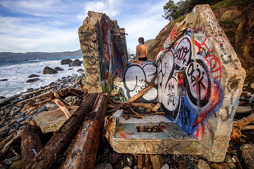 graffiti on concrete ruins on seashore, concrete, driftwood, graffiti, ocean, rocks, ruins, sea, seashore, sitting, woman, yassmine