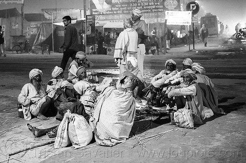 group of babas sitting around a campfire on a street corner - kumbh mela 2013 (india), babas, beard, campfire, circle, hindu pilgrimage, hinduism, kumbh mela, men, night, pilgrim, sadhus, sitting