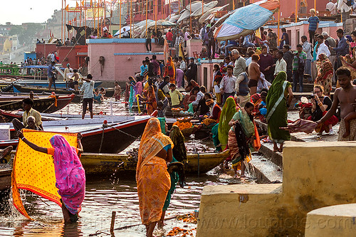 hindu bathing on the ghats of varanasi (india), backloght, bathing pilgrims, crowd, ganga, ganges river, ghats, hindu, hinduism, holy bath, holy dip, indian women, mooring, nadi bath, river bank, river bathing, river boats, sarees, sari, varanasi