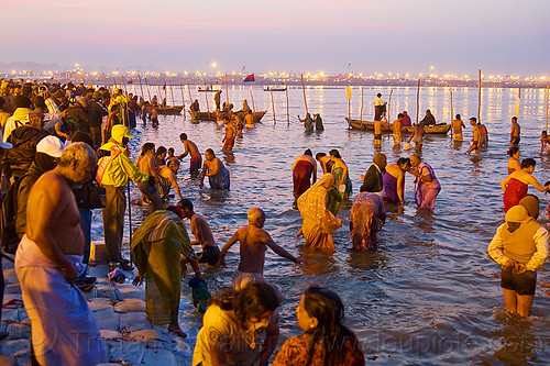 hindu pilgrims bathing in the ganges river at sangam - kumbh mela 2013 (india), bathing pilgrims, crowd, dawn, fence, ganga, ganges river, hindu pilgrimage, hinduism, holy bath, holy dip, kumbh mela, men, nadi bath, paush purnima, ritual bath, river bathing, river boats, street lights, triveni sangam, women