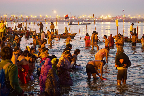 hindu pilgrims bathing in the ganges river at sangam - kumbh mela 2013 (india), bathing pilgrims, crowd, dawn, fence, ganga, ganges river, hindu pilgrimage, hinduism, holy bath, holy dip, kumbh mela, men, nadi bath, paush purnima, ritual bath, river bathing, river boats, street lights, triveni sangam, women