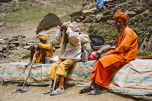 hindu pilgrims sitting, resting on trail - amarnath yatra (pilgrimage) - amarnath yatra (pilgrimage) - kashmir, amarnath yatra, bhagwa, headwear, hiking canes, hindu holy man, hindu pilgrimage, hinduism, kashmir, mountain trail, mountains, pilgrims, resting, saffron color, walking sticks