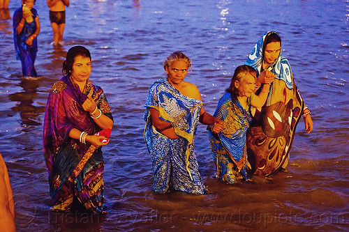 hindu women bathing in the ganges river at dawn, bathing pilgrims, dawn, ganga, ganges river, hindu pilgrimage, hinduism, holy bath, holy dip, indian woman, indian women, kumbh mela, men, nadi bath, old woman, paush purnima, ritual bath, river bathing, saree, triveni sangam
