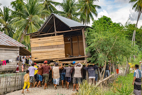 house moving - people carry a house to a new location, crowd, house relocation, men, road, structure relocation, village