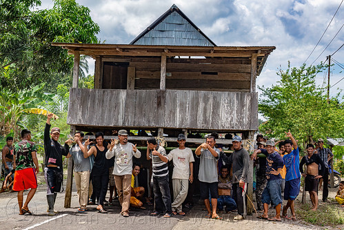 house moving - people carry a house to a new location in the village, crowd, house relocation, men, road, structure relocation, village