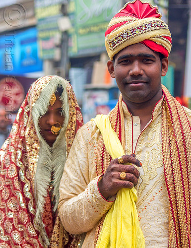 indian wedding - proud indian groom with turban holding bride in tow like a trophy (india), bride, dressed-up, gold jewelry, groom, hand mehndi, headdress, indian wedding, indian woman, man, nose piercing, nostril piercing, piercing jewelry, scarf, traditional, turban, varanasi