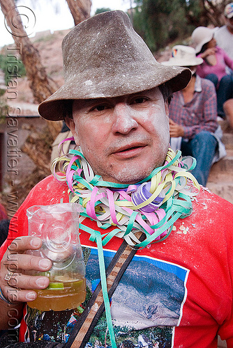 indigenous man celebrating and drinking - carnaval de tilcara (argentina), andean carnival, argentina, carnaval de la quebrada, carnaval de tilcara, confettis, drink, drinking, hat, man, noroeste argentino, quebrada de humahuaca, serpentine throws, talk powder