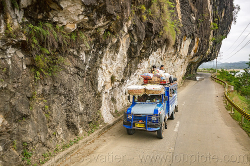 jeepney on road with overhanging cliff (philippines), cliff, cordillera, jeepneys, overhanging rock, passengers, philippines, road, roof, sitting