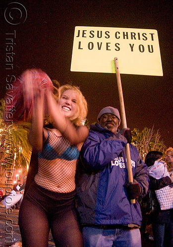 jesus loves the great san francisco pillow fight 2009, down feathers, fishnet clothing, fishnet top, holding sign, jesus loves you, man, night, pillows, woman, world pillow fight day