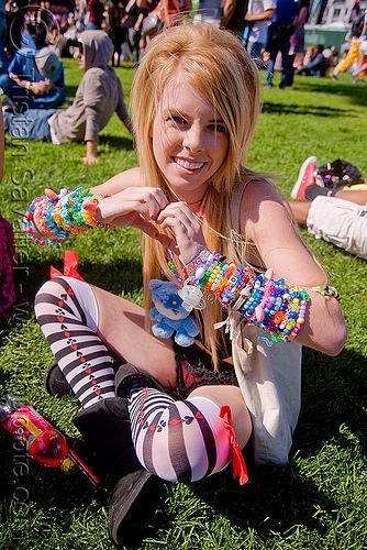 kandi kid with cuffs making heart sign, beads, blonde, clothing, cross-legged, fashion, heart sign, kandi bracelets, kandi cuffs, kandi kid, kandi raver, lovevolution, sitting, woman