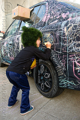 kid chalk writing on car - burning man decompression, black car, chalk writing, child, graffiti, kid, street art, vandalism
