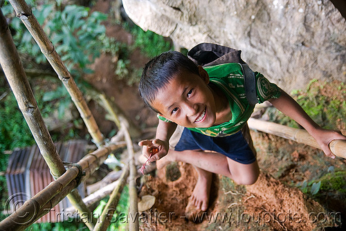 kid on bamboo ladder to cliff cave near vang vieng (laos), bamboo ladder, boy, caving, child, cliff, guide, kid, laos, natural cave, peace sign, spelunking, vang vieng