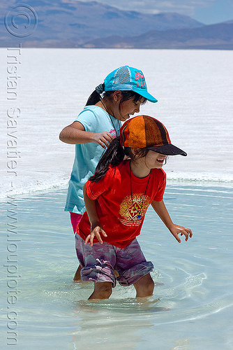 kids wading in salt pool - salinas grandes - salar (argentina), argentina, blue sky, caps, children, halite, jujuy, kids, noroeste argentino, rock salt, salar, salinas grandes, salt bed, salt flats, salt lake, salt pool, wading, white