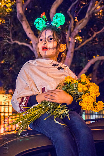 little girl holding bunch of marigold flowers - dia de los muertos, child, day of the dead, dia de los muertos, face painting, facepaint, flower bunch, flowers, green skulls, halloween, headdress, kid, little girl, marigold, night, sitting, sugar skull makeup